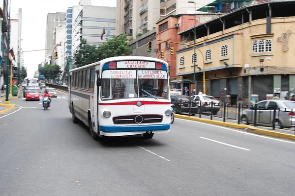 Caracas, Venezuela. İkonik otobüs şehrin merkezinde bir cadde boyunca yürüyor..