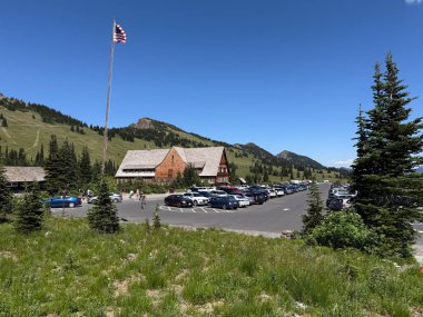 17 Temmuz 2025 'te Mount Rainier Ulusal Parkı' nda ağaçlar, arabalar, kulübeler, insanlar ve ABD bayrağı..