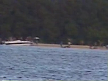 İnsanlar sahilde ve teknelerde eğleniyor. Carenero, Miranda State, Venezuela, 1 Ocak 2001. 8 mm 'lik video. Yazı.