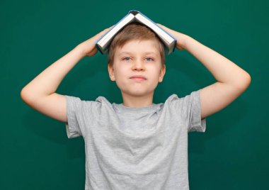 Çocuk elinde açık bir kitapla.