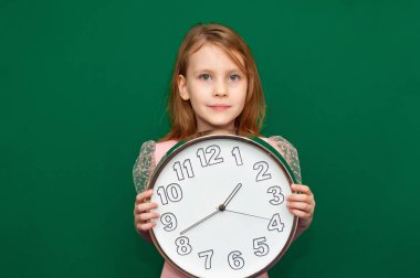 Kızın elinde kocaman bir saat var.