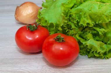 Masada kırmızı domates ve marul var. Vejetaryen sağlıklı yiyecekler
