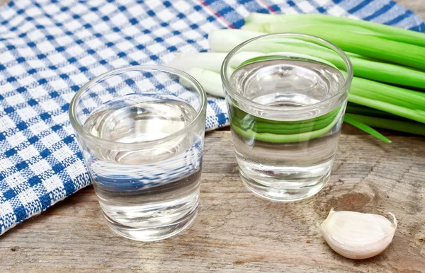Vodka with onion and garlic on a wooden table — Stock Image Vodka with onion and garlic on a wooden table Stock Picture