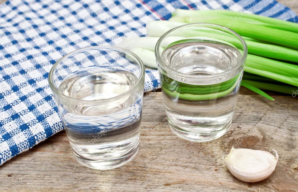 Vodka with onion and garlic on a wooden table — Stock Photo © pavlentii