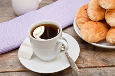 Ahşap masa üzerinde kruvasan ile kahve 