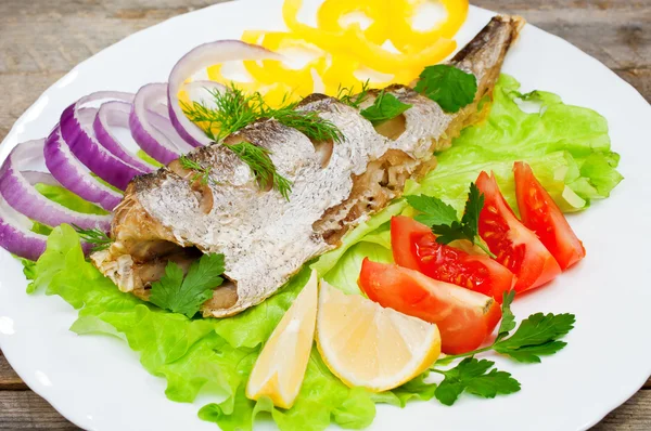 Fish hake baked with vegetables on a plate — Stock Photo, Image