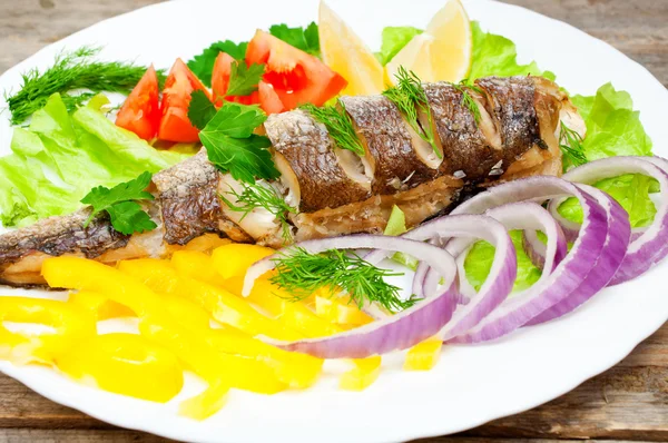 Merlu de poisson cuit avec des légumes dans une assiette — Photo