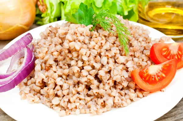 Buckwheat groats in a bowl on a wooden table — Stock Photo, Image