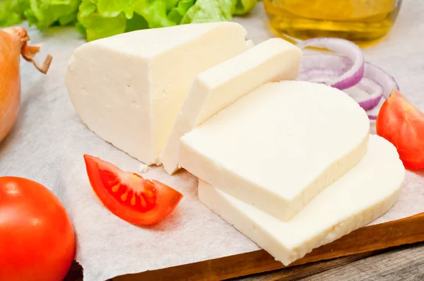 Zacht geitenkaas in een kom op een houten tafel met groenten — Stockfoto