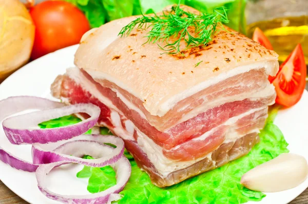 Smoked bacon on a plate with vegetables — Stock Photo, Image