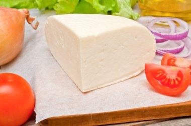 Bir kase sebze ile ahşap bir masa üzerinde yumuşak keçi peyniri