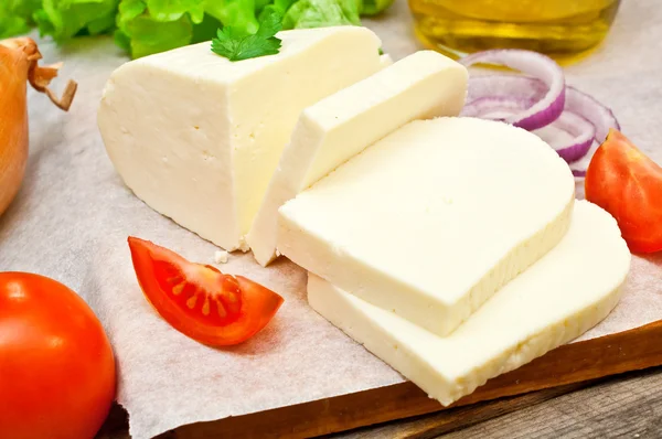 Měkký kozí sýr v misce na dřevěný stůl se zeleninou — Stock fotografie