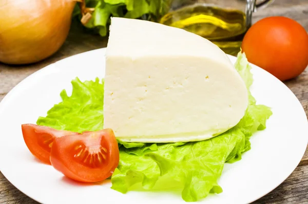 Měkký kozí sýr v misce na dřevěný stůl se zeleninou — Stock fotografie