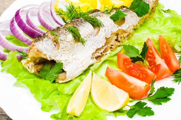 Merluza de pescado al horno con verduras en un plato — Foto de Stock