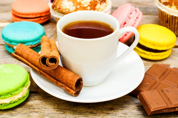 Amaretto con tè, cioccolato e bastoncini di cannella su una linguetta di legno — Foto Stock