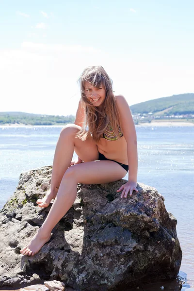 Girl bathing suit sitting on big stone — Stock Photo, Image