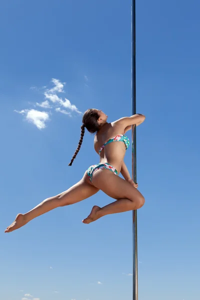 Bailarina con coleta realiza acrobática en polo — Foto de Stock