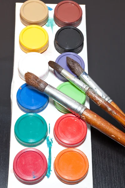 Brushes and colored paint artist on gray background — Stock Photo, Image