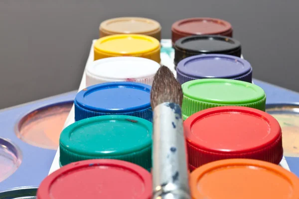 Brushes and colored paint artist on gray background — Stock Photo, Image