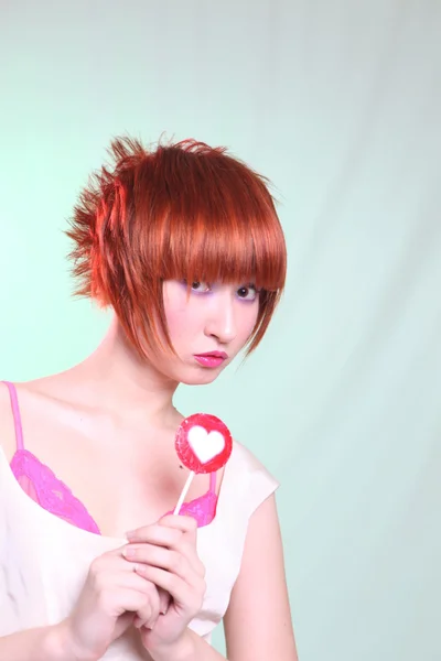 Fille aux cheveux rouges avec coeur de sucette — Photo