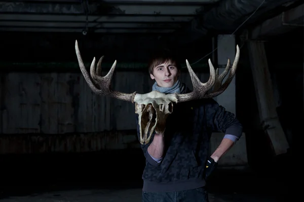 Young man with a deer skull with horns — Stock Photo, Image