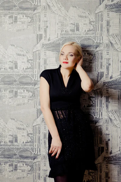 Young blond woman posing in black dress — Stock Photo, Image