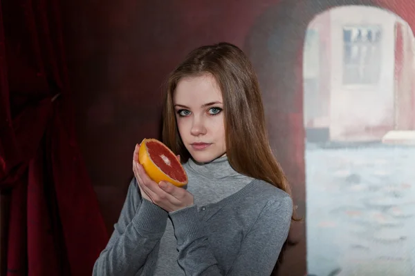 Meisje met halve grapefruit — Stockfoto