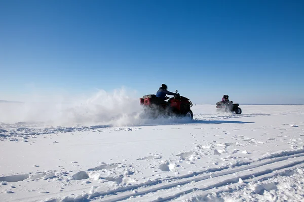 Άνδρας ιππασία ποδήλατο quad στη χειμώνα χιονισμένο πεδίο — Φωτογραφία Αρχείου