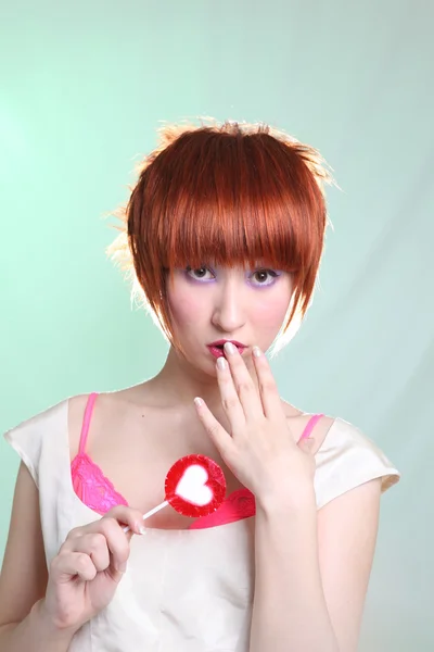 Девушка в атласном платье с конфетным сердцем — стоковое фото