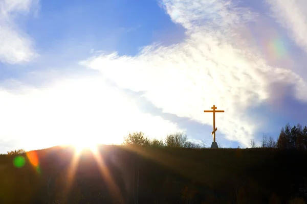 Cruz cristiana en una colina contra el cielo Imágenes de stock libres de derechos