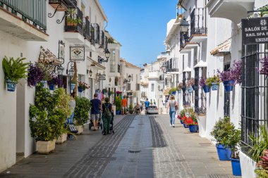 Mijas, İspanya - 6 Mayıs 2023: Güneşli bir günde İspanya 'nın Mijas kentinde güzel caddelerde yürüyen turistler