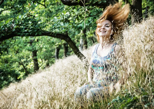 Mooie jonge brunette gooit haar in de natuur — Stockfoto