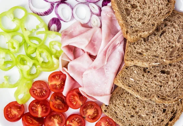 Tasty whole wheat bread with ham, onion, paprika and tomatoes — Stock Photo, Image