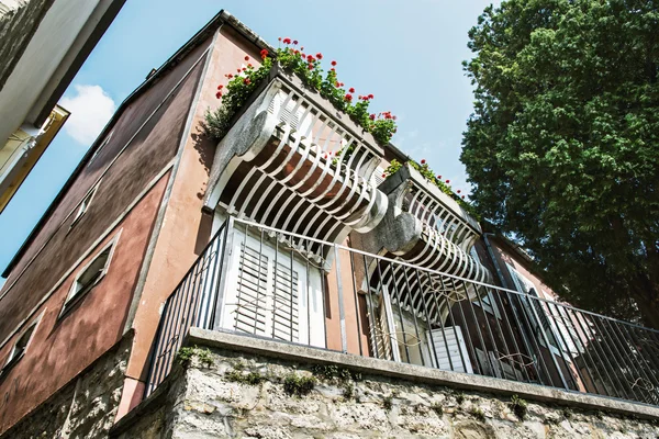 Gammalt hus med balkong och blommor, arkitektoniska temat — Stockfoto