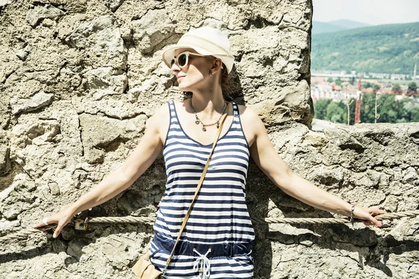 Young woman in sailor outfit is leaning on the old wall — Stock Photo, Image