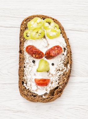 Komik surat yapılmış ekmek, tereyağı, sosis, kırmızı biber, kara biber