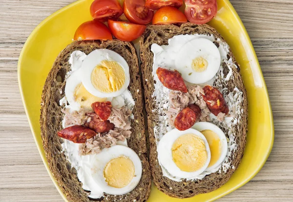 Sliced whole wheat bread with butter, tuna, sausage, cherry toma — Stock Photo, Image