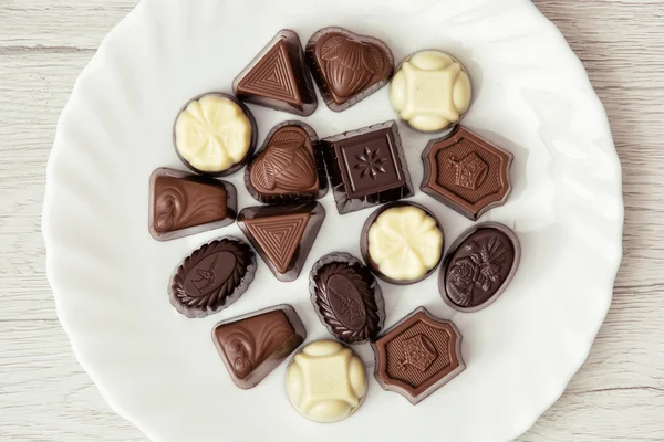 Various belgian pralines on the white plate, sweet food — Stock Photo, Image