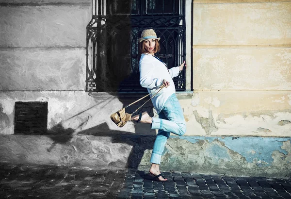Красивая женщина позирует со стильной сумочкой во дворе, от — стоковое фото
