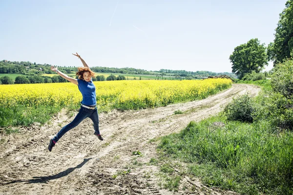 Jubelnde Kaukasierin springt in Rapsfeld — Stockfoto