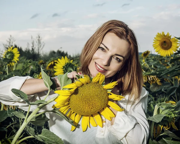 Krásná žena, pózuje ve slunečnicovém poli, krásy a přírody — Stock fotografie