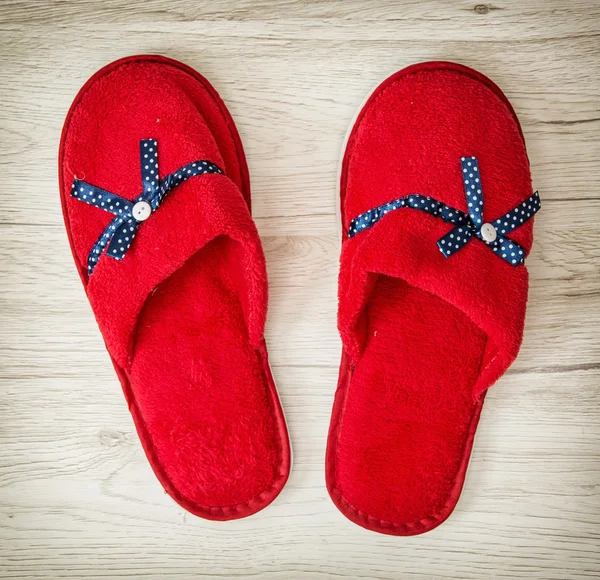 Red slippers with blue ribbon on the wooden background, retro fa — Stock Photo, Image