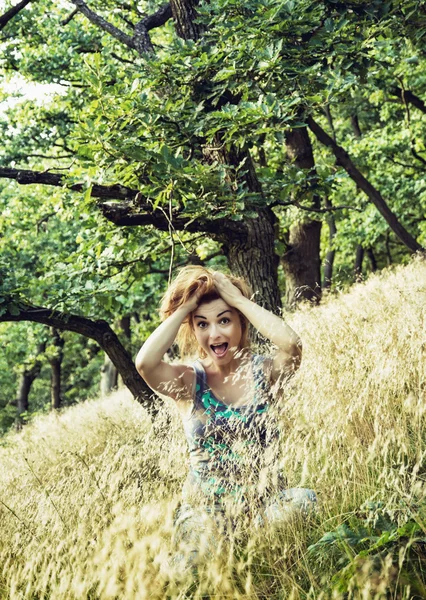 Crazy young caucasian brunette holds hair in nature — Stock Photo, Image