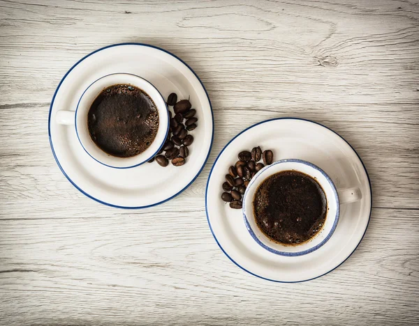 Two ceramic cups of coffee on the wooden background — Stock Photo, Image