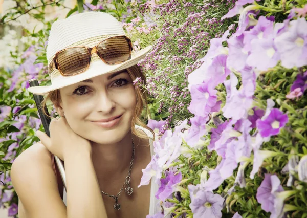 Young caucasian tourist woman posing with beautiful flowers — Stockfoto