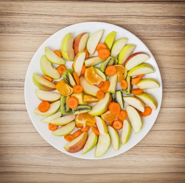 Skivade morötter, äpple, kiwi, tangerine och apelsiner — Stockfoto