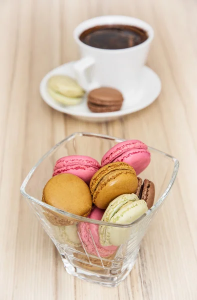 Macarons coloridos franceses con taza de café negro — Foto de Stock