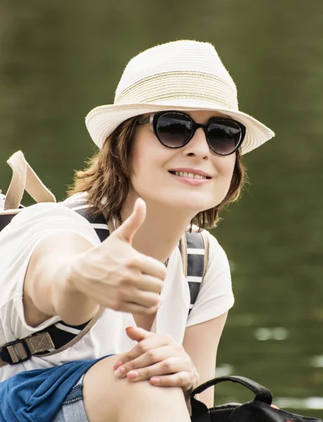 Neşeli turist kadın kadar başparmak ile poz — Stok fotoğraf