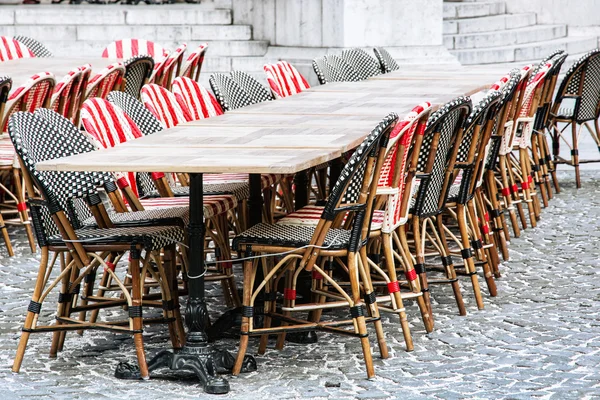 Proutěné židle a kamenné tabulky v zahradní restauraci — Stock fotografie