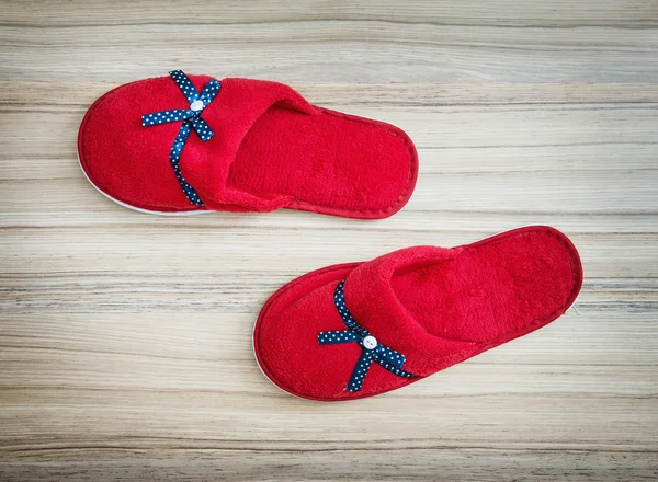 Red slippers with blue ribbon on the wooden background — Stock Photo, Image